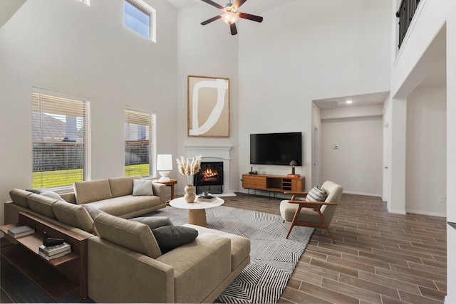 living room with ceiling fan and a towering ceiling