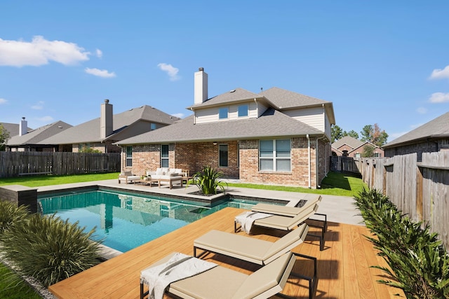 view of swimming pool with an outdoor living space and a wooden deck