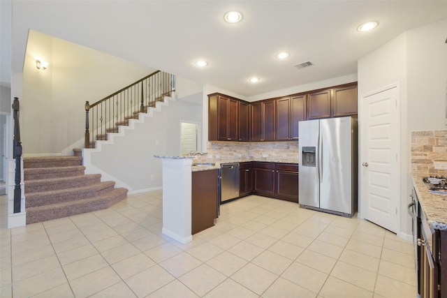 kitchen featuring stainless steel appliances, decorative backsplash, light tile patterned floors, and light stone counters