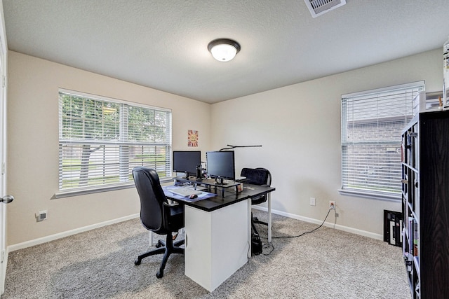 carpeted home office with a textured ceiling