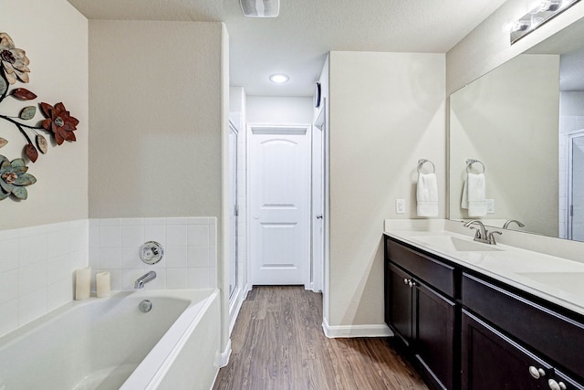 bathroom with hardwood / wood-style flooring, separate shower and tub, and vanity