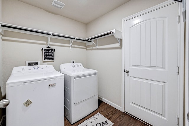 clothes washing area featuring dark hardwood / wood-style flooring and washer and clothes dryer