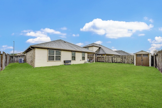 rear view of house with a lawn, central AC, and a storage shed