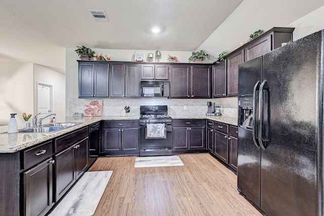 kitchen featuring black appliances, light hardwood / wood-style floors, sink, and dark brown cabinetry