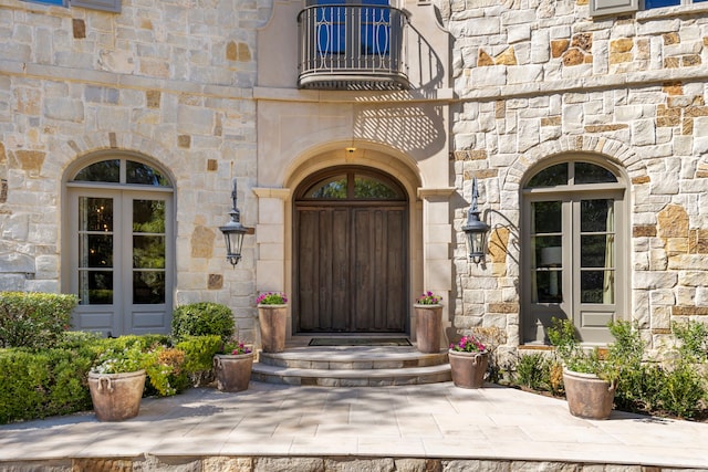 property entrance with a balcony and french doors