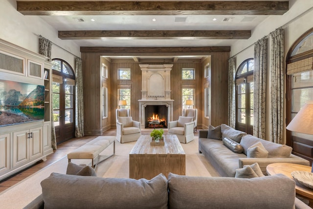 living room with a large fireplace, light hardwood / wood-style flooring, and french doors