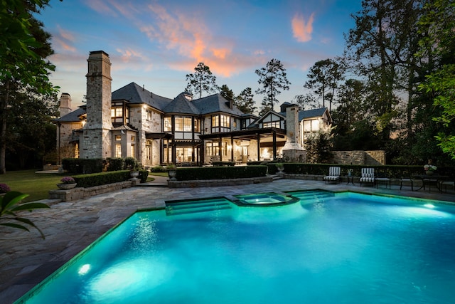 pool at dusk featuring a patio area