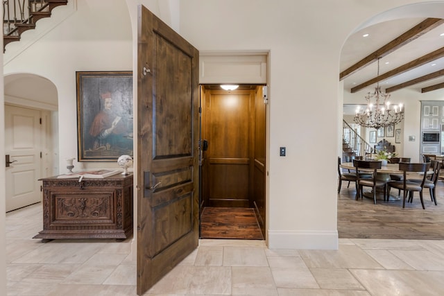 hallway featuring a notable chandelier and beam ceiling