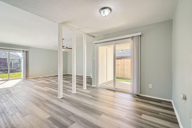 unfurnished room with a textured ceiling, ceiling fan, and light hardwood / wood-style floors