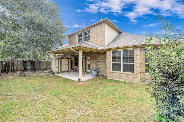 back of property featuring an outdoor fire pit, a yard, a storage unit, and a patio