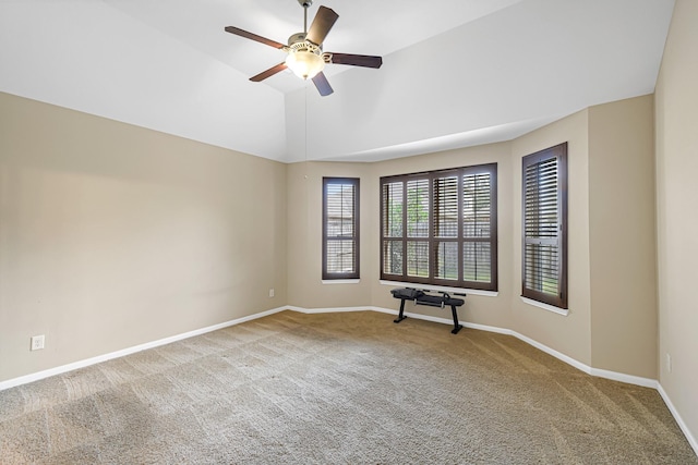 carpeted empty room featuring vaulted ceiling and ceiling fan