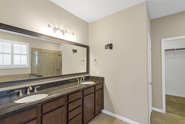 bathroom featuring tile patterned flooring, walk in shower, and vanity