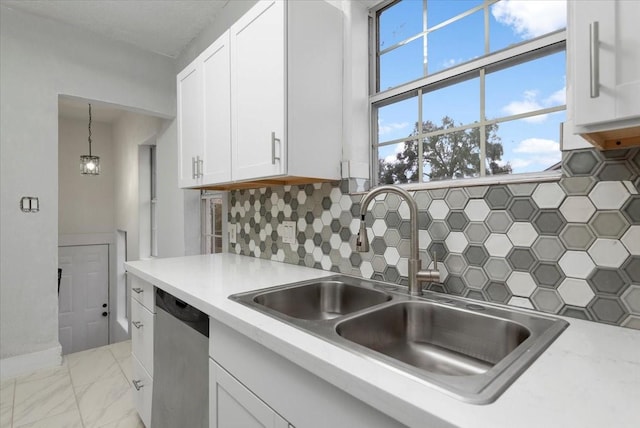 kitchen featuring stainless steel dishwasher, pendant lighting, decorative backsplash, white cabinetry, and sink