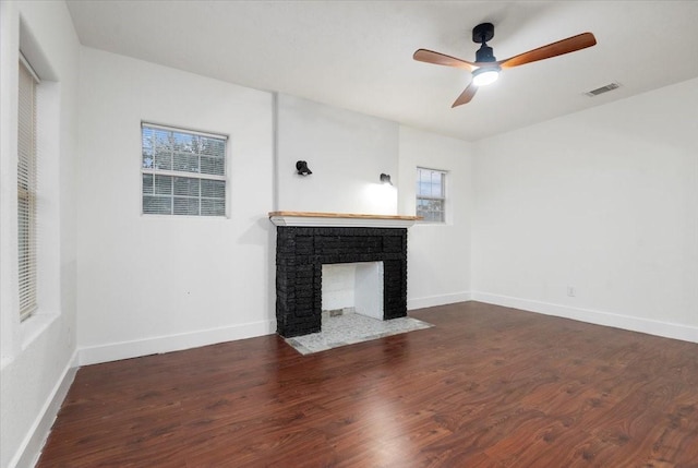 unfurnished living room featuring ceiling fan, a multi sided fireplace, and dark hardwood / wood-style flooring