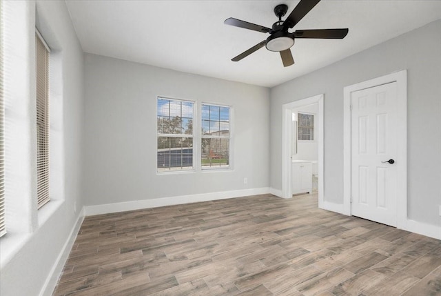 unfurnished bedroom featuring hardwood / wood-style flooring, ceiling fan, and connected bathroom