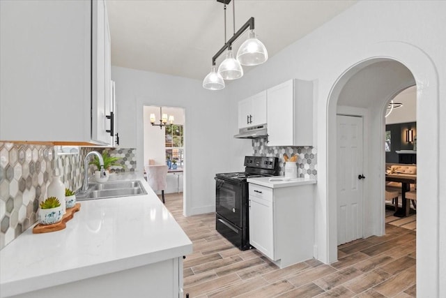 kitchen featuring black / electric stove, hanging light fixtures, tasteful backsplash, white cabinets, and sink