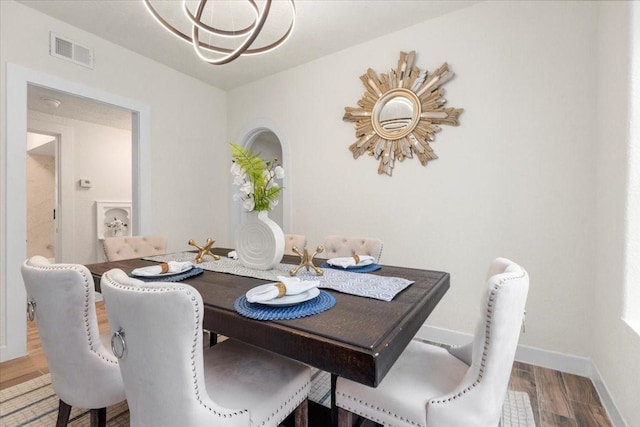 dining space featuring hardwood / wood-style floors and a notable chandelier