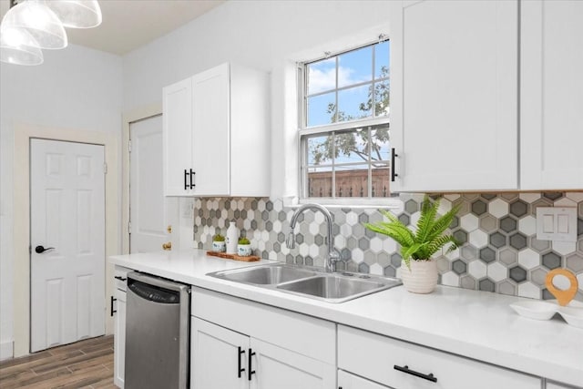 kitchen with hardwood / wood-style flooring, dishwasher, pendant lighting, white cabinets, and sink