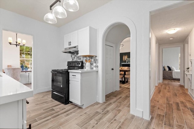 kitchen with decorative light fixtures, white cabinetry, tasteful backsplash, a chandelier, and black range with electric cooktop