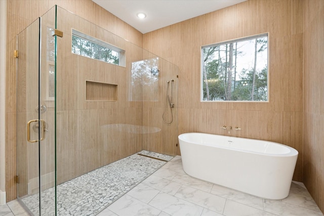 bathroom featuring plenty of natural light and shower with separate bathtub