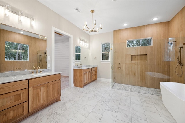 bathroom with independent shower and bath, vanity, and a notable chandelier