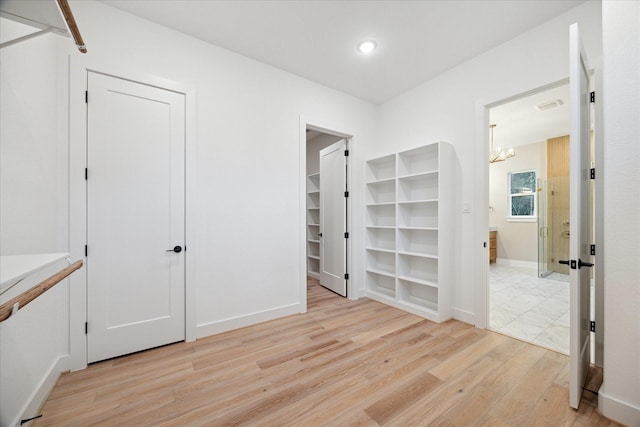 interior space with light hardwood / wood-style floors and a notable chandelier