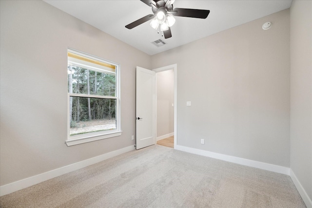 carpeted spare room featuring ceiling fan