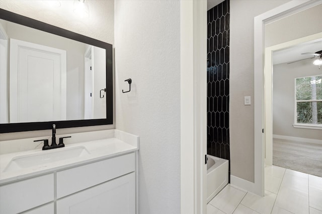 bathroom featuring ceiling fan, tiled shower / bath, tile patterned floors, and vanity