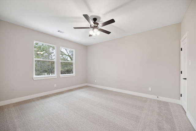 carpeted spare room featuring ceiling fan