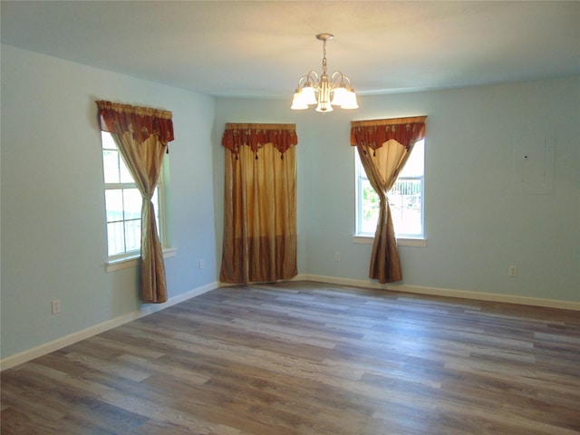 unfurnished room with dark wood-type flooring and a chandelier