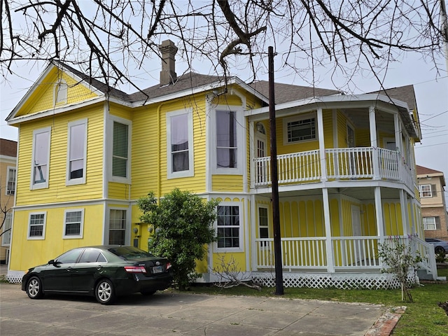 view of front of house with covered porch and a chimney