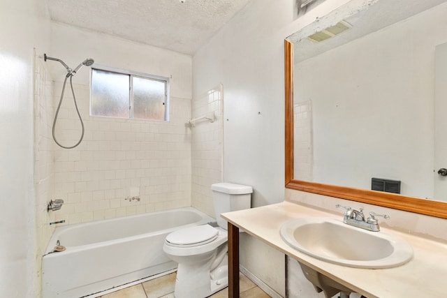 full bathroom with toilet, tiled shower / bath, tile patterned flooring, sink, and a textured ceiling