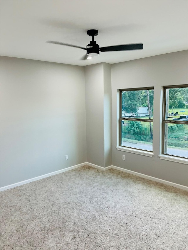 carpeted spare room featuring ceiling fan