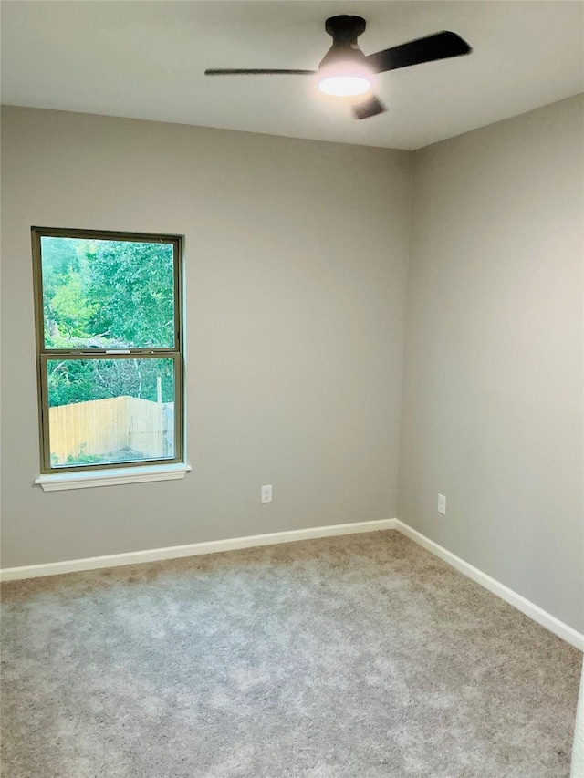 carpeted spare room with ceiling fan