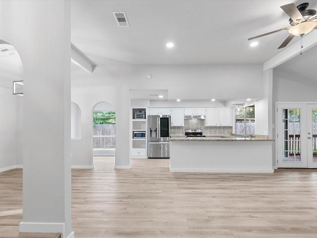 kitchen featuring stainless steel appliances, light stone countertops, kitchen peninsula, ceiling fan, and white cabinets