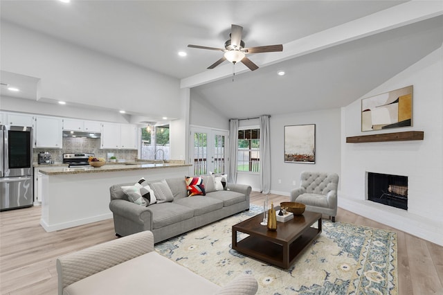 living room with light hardwood / wood-style floors, vaulted ceiling with beams, ceiling fan, french doors, and sink