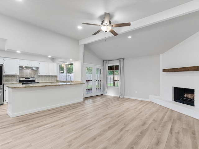 unfurnished living room featuring light wood-type flooring, ceiling fan, french doors, and lofted ceiling with beams