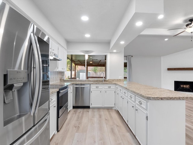 kitchen featuring white cabinetry, light hardwood / wood-style floors, kitchen peninsula, and appliances with stainless steel finishes