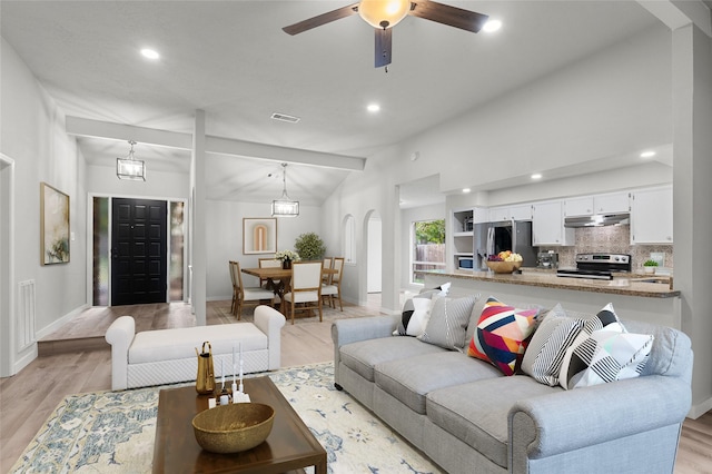 living room with light hardwood / wood-style floors, ceiling fan, and vaulted ceiling