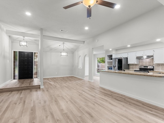 unfurnished living room featuring ceiling fan with notable chandelier, vaulted ceiling, and light hardwood / wood-style floors