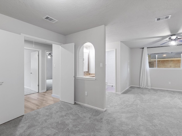 carpeted empty room with a textured ceiling and ceiling fan