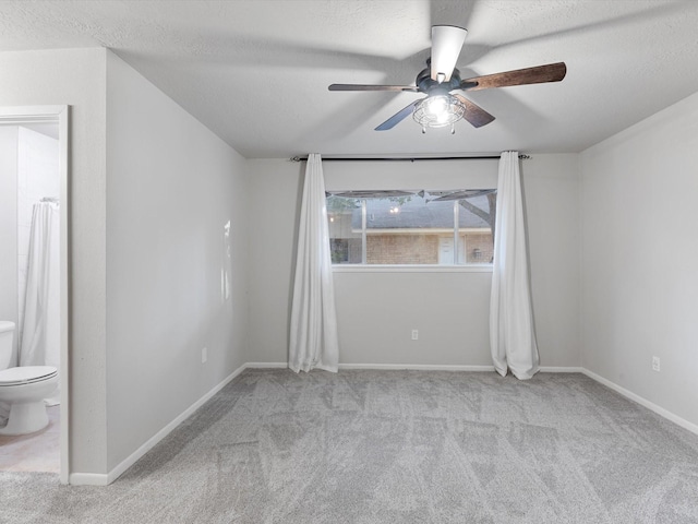 carpeted empty room with a textured ceiling and ceiling fan