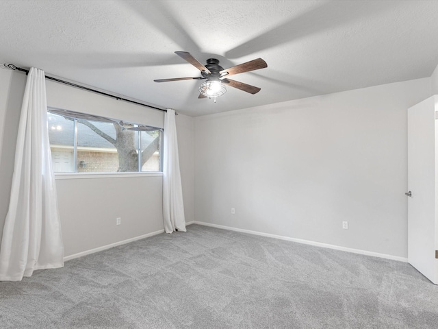 spare room featuring a textured ceiling, ceiling fan, and light colored carpet