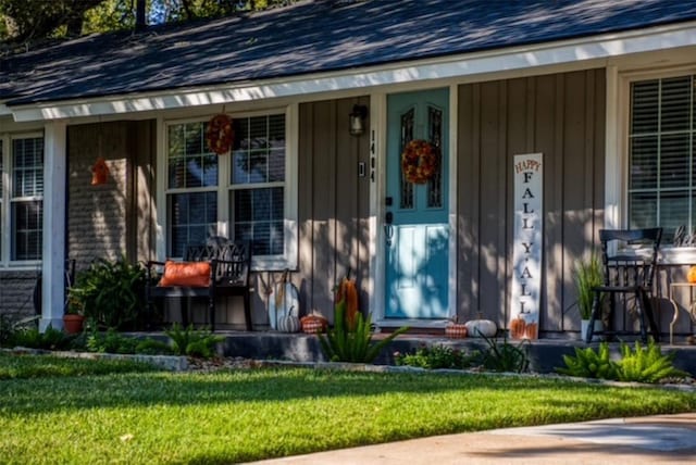 property entrance with covered porch and a lawn