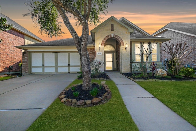 view of front of house featuring a garage and a yard