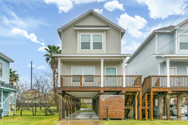 view of front of home with covered porch, a front lawn, and a carport