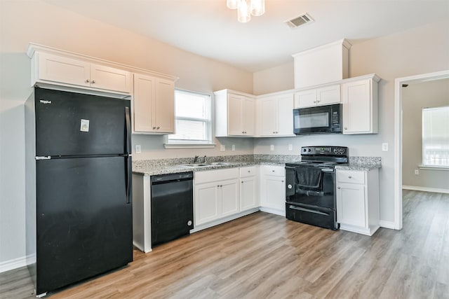 kitchen with sink, white cabinetry, light hardwood / wood-style flooring, light stone countertops, and black appliances