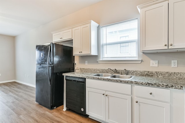 kitchen featuring black appliances, light wood-type flooring, light stone countertops, sink, and white cabinetry