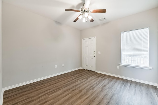 empty room with dark hardwood / wood-style flooring and ceiling fan