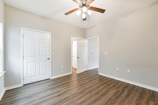 unfurnished bedroom with ceiling fan and dark wood-type flooring